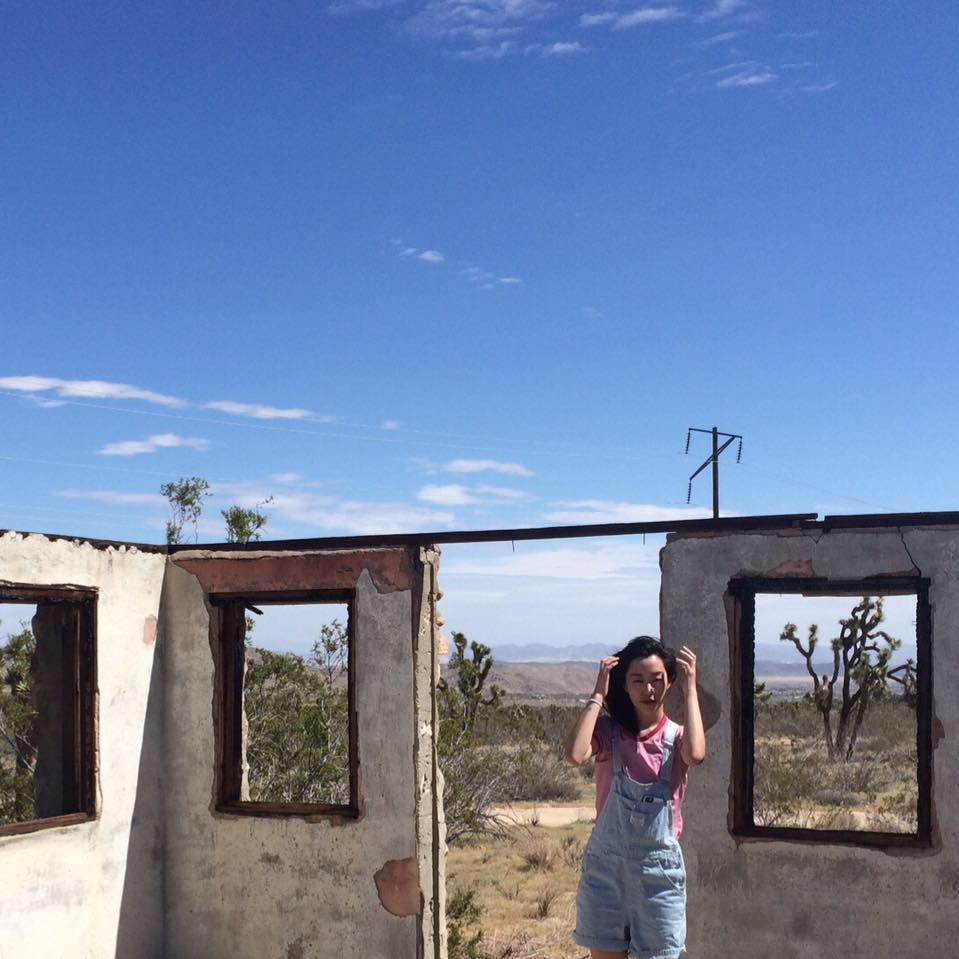 Image of a girl standing in the desert with raised hands